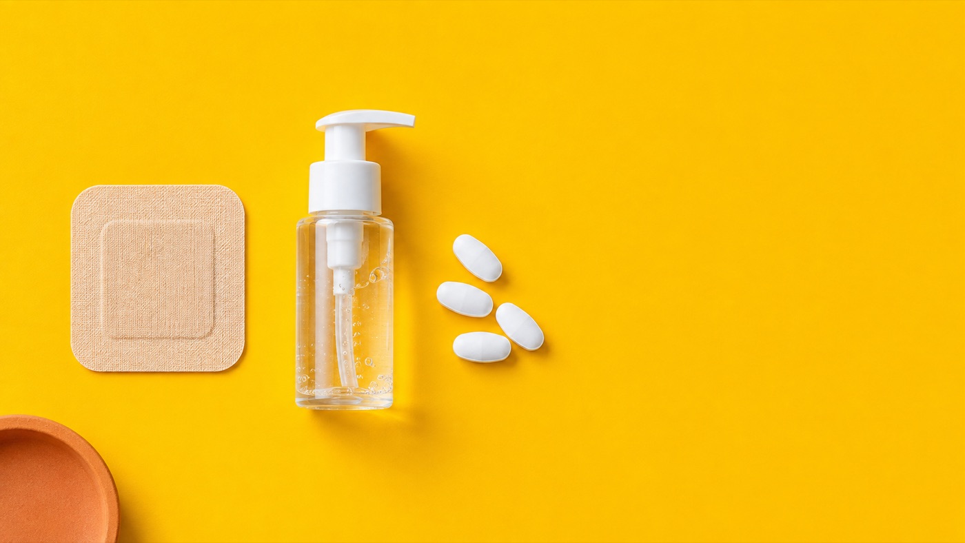 A skin patch, a pump dispenser of gel and white tablets on a bright yellow background, three forms of hormone therapy